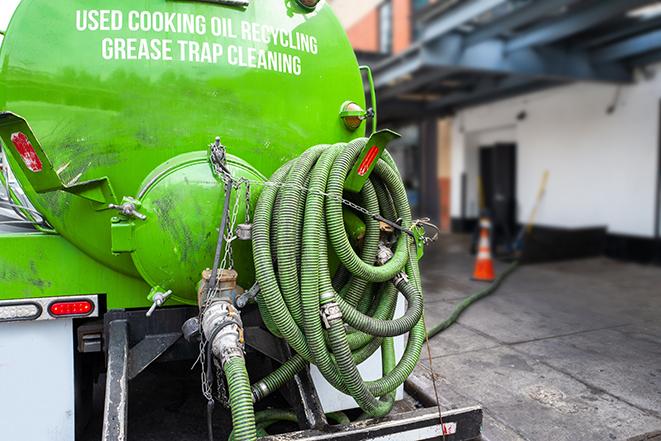 a technician pumping a grease trap in a commercial building in Dayton